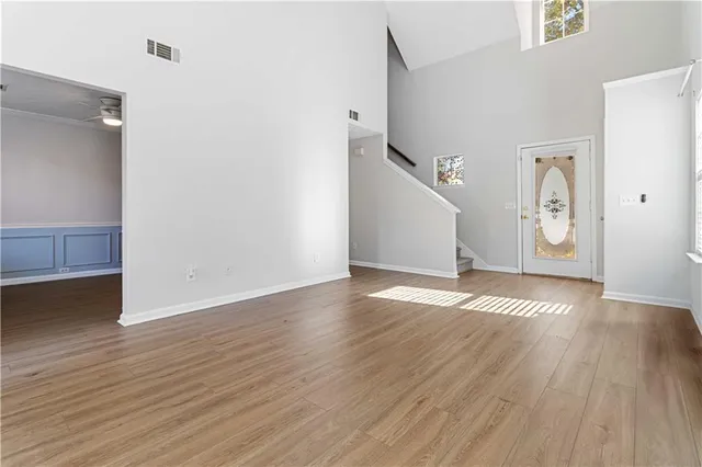 an empty room with wooden floor and staircase