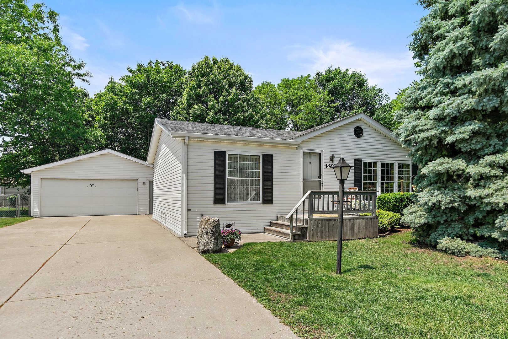 a front view of a house with a yard and green space