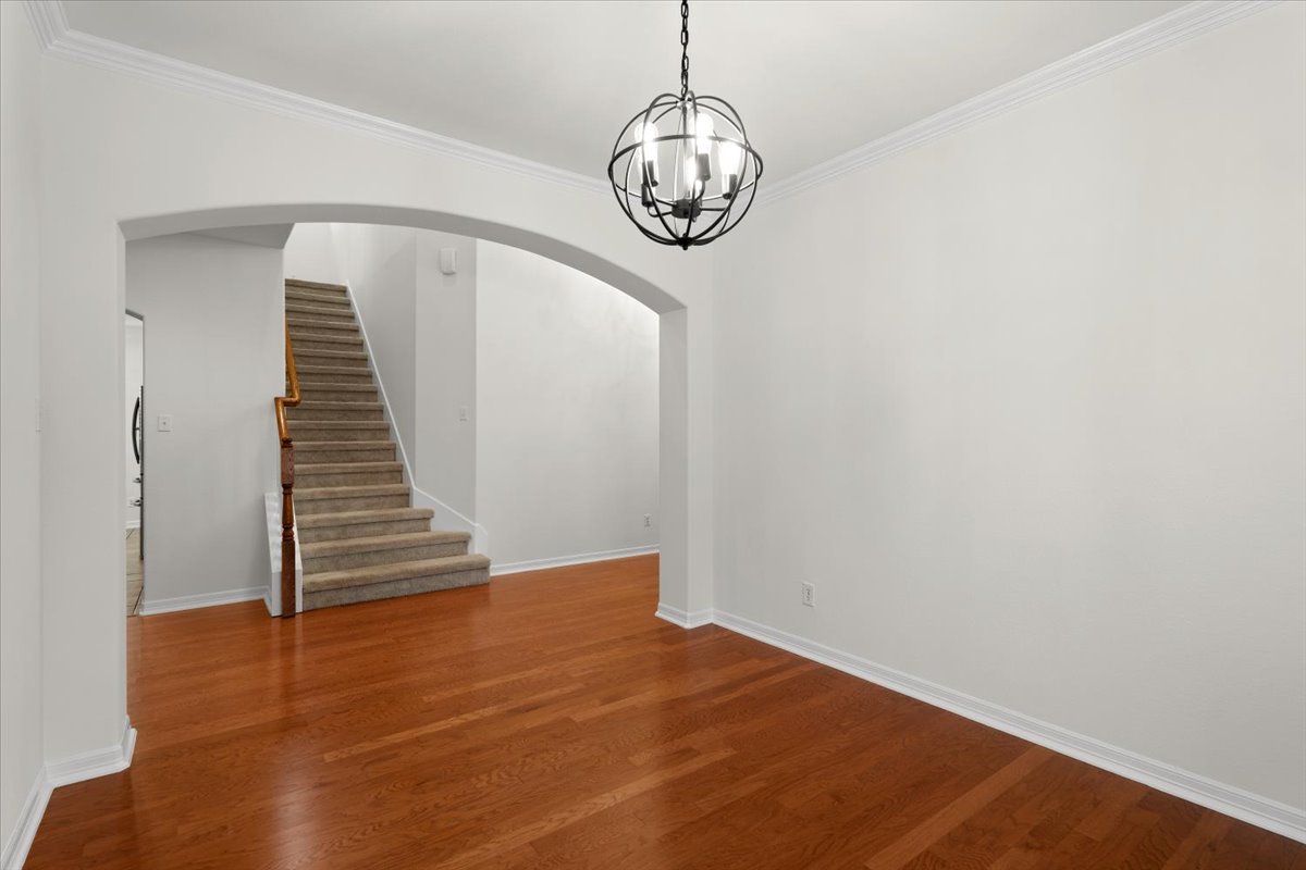 2304 Village View Loop Pflugerville, TX 78660 - Photo 20 of 40 Hardwood floors guide you through the entrance foyer, revealing a stylish chandelier and elegant crown molding.