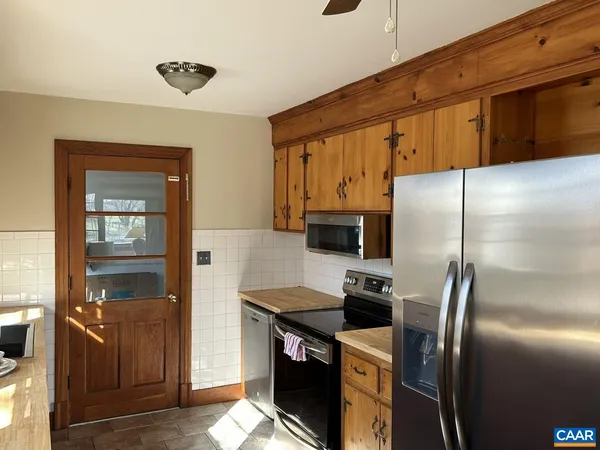 a kitchen with stainless steel appliances granite countertop a refrigerator a stove and a sink with wooden floor