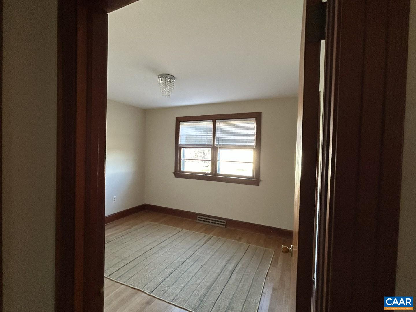 7714 Blenheim Road Scottsville, VA 24590 - Photo 18 of 35 a view of an empty room with wooden floor and a window