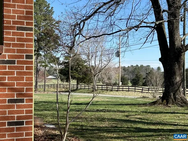 a view of a tennis ground with a white house