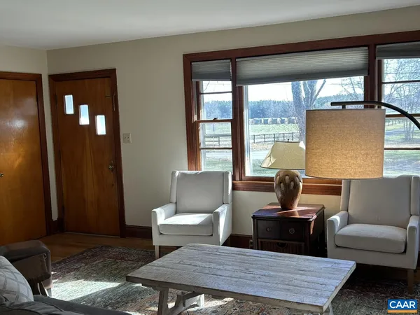 a living room with furniture and a floor to ceiling window
