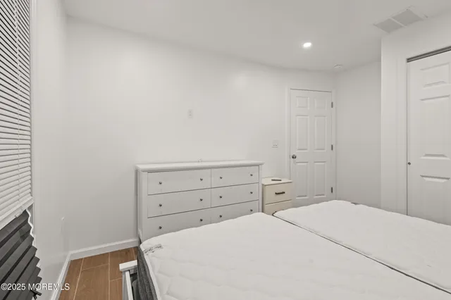 a bedroom with a bed and a flat tv screen on wall