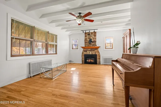 a view of an empty room with window and wooden floor