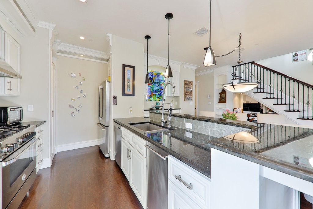 161 Tudor Street, Unit 4 Boston, MA 02127 - Photo 11 of 28 a kitchen with stainless steel appliances granite countertop a sink a stove and a wooden floor