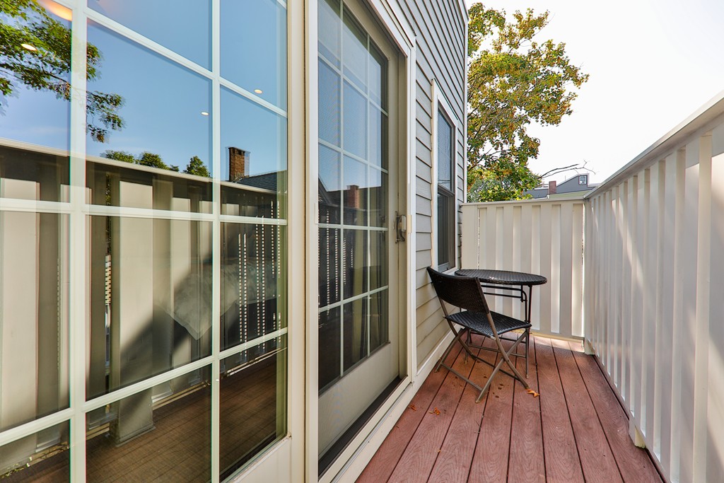 161 Tudor Street, Unit 4 Boston, MA 02127 - Photo 18 of 28 a balcony with wooden floor table and chairs