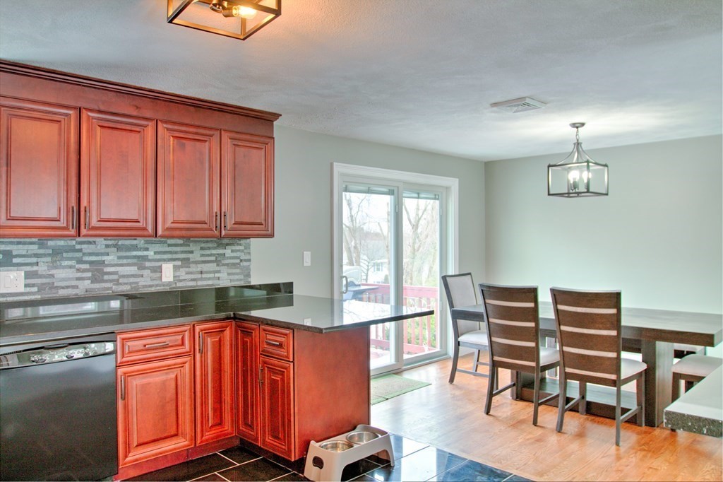 143 North Road Chelmsford, MA 01824 - Photo 4 of 42 a kitchen with stainless steel appliances granite countertop a stove top oven a dining table and chairs with wooden floor