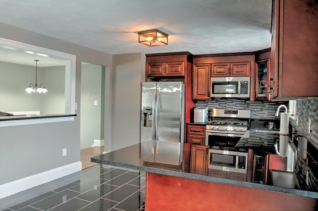 143 North Road Chelmsford, MA 01824 - Photo 8 of 42 a kitchen with stainless steel appliances a refrigerator and a stove top oven