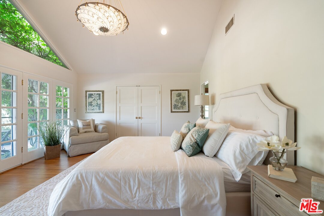 3710 Eureka Drive Studio City, CA 91604 - Photo 37 of 51 a bedroom with a large bed and a chandelier