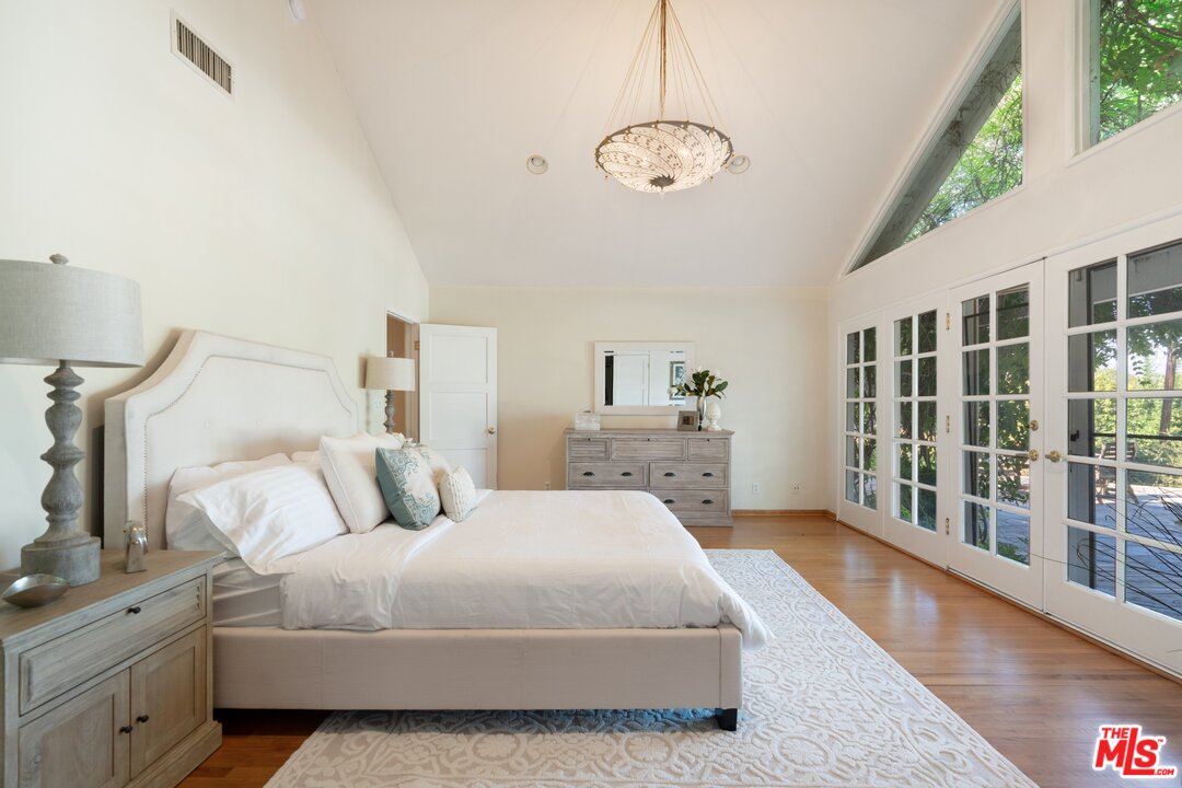 3710 Eureka Drive Studio City, CA 91604 - Photo 40 of 51 a spacious bedroom with a large bed and a chandelier