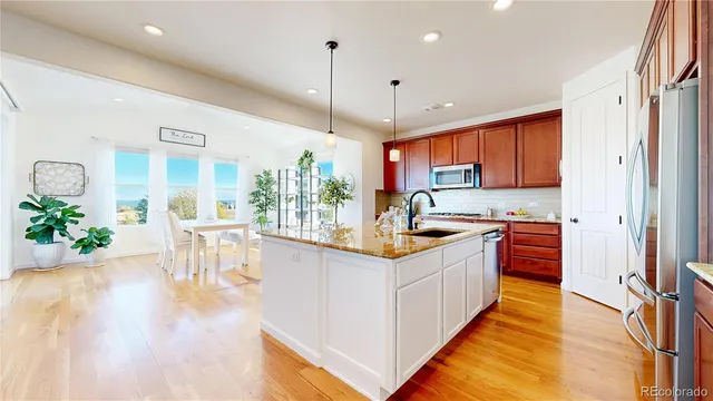 a kitchen with stainless steel appliances granite countertop sink stove and wooden cabinets