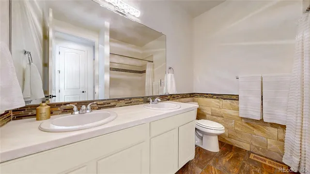 a bathroom with a granite countertop sink a toilet and a tub