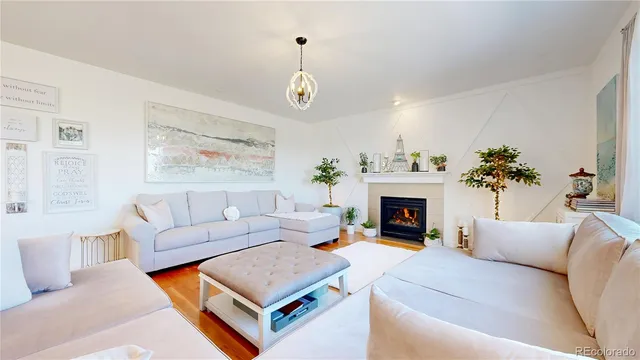 a living room with furniture a chandelier and a fireplace