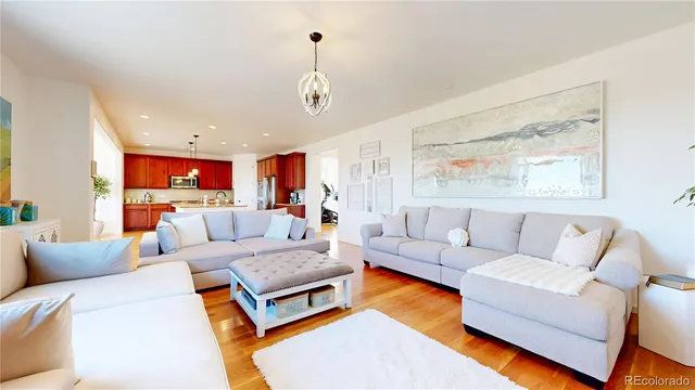 a living room with furniture kitchen view and a large window
