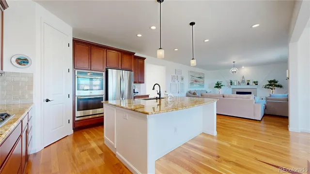 a large kitchen with kitchen island a large counter top space a sink stainless steel appliances and cabinets