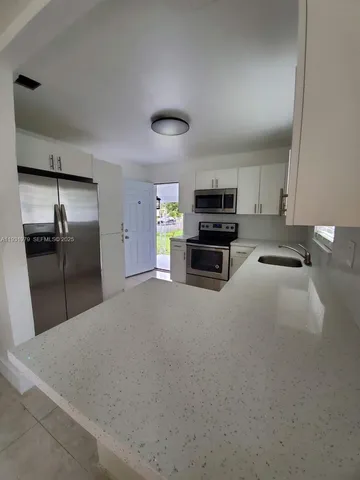 a kitchen with stainless steel appliances a refrigerator and a stove top oven