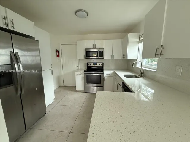 a kitchen with stainless steel appliances granite countertop a refrigerator and a sink