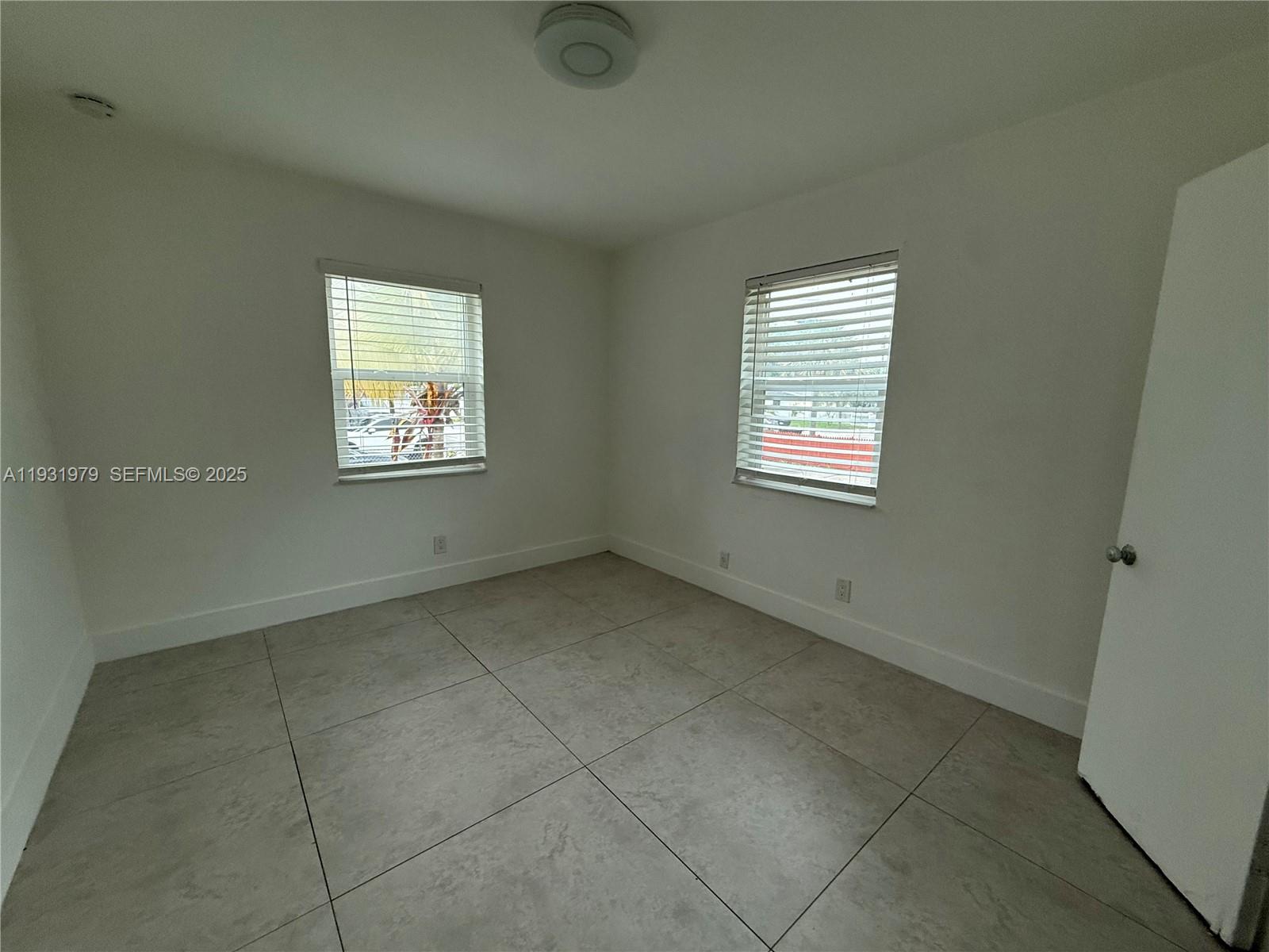 1448 Northeast 152nd Street North Miami Beach, FL 33162 - Photo 7 of 11 an empty room with windows