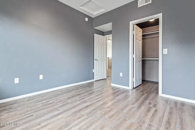 an empty room with wooden floor and closet