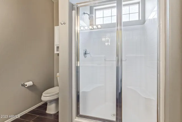 a bathroom with a granite countertop toilet a sink and a large mirror