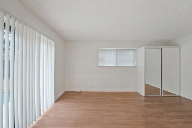 a view of an empty room with wooden floor