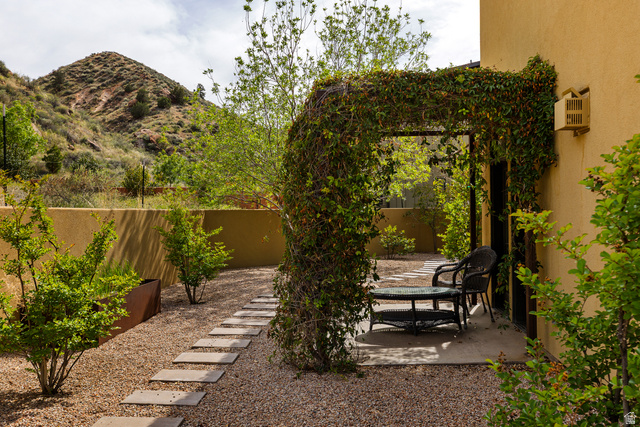 105 River Bend Circle, Unit 105 Springdale, UT 84767 - Photo 46 of 56 Outdoor patio area featuring an ivy-covered pergola, a gravel ground cover, stepping stone pathway, and mature plantings
