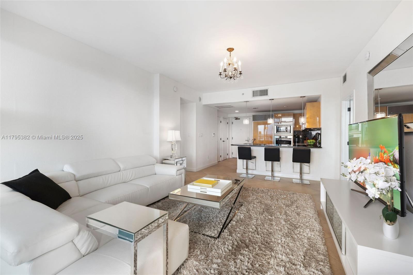 6799 Collins Avenue, Unit 1106 Miami Beach, FL 33141 - Photo 14 of 43 a living room with furniture flowerpot and a chandelier