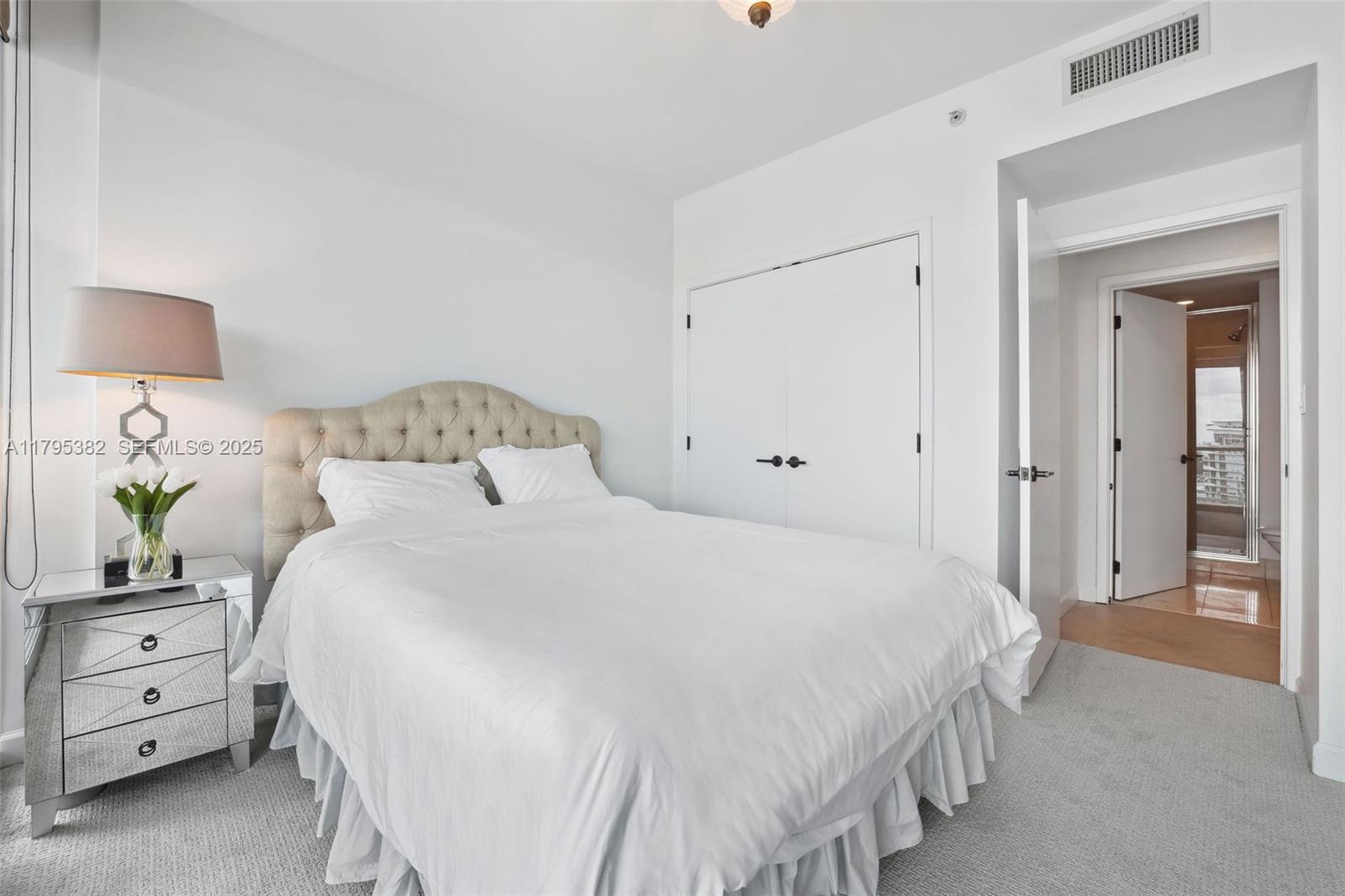 6799 Collins Avenue, Unit 1106 Miami Beach, FL 33141 - Photo 21 of 43 a bedroom with a bed and a lamp