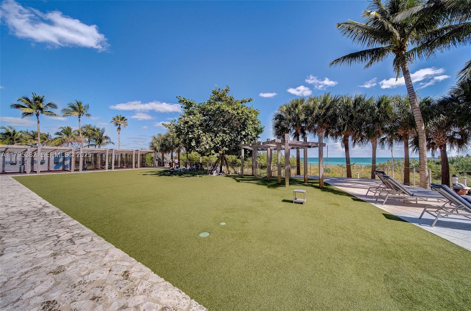 6799 Collins Avenue, Unit 1106 Miami Beach, FL 33141 - Photo 27 of 43 a view of a swimming pool with a table and chairs