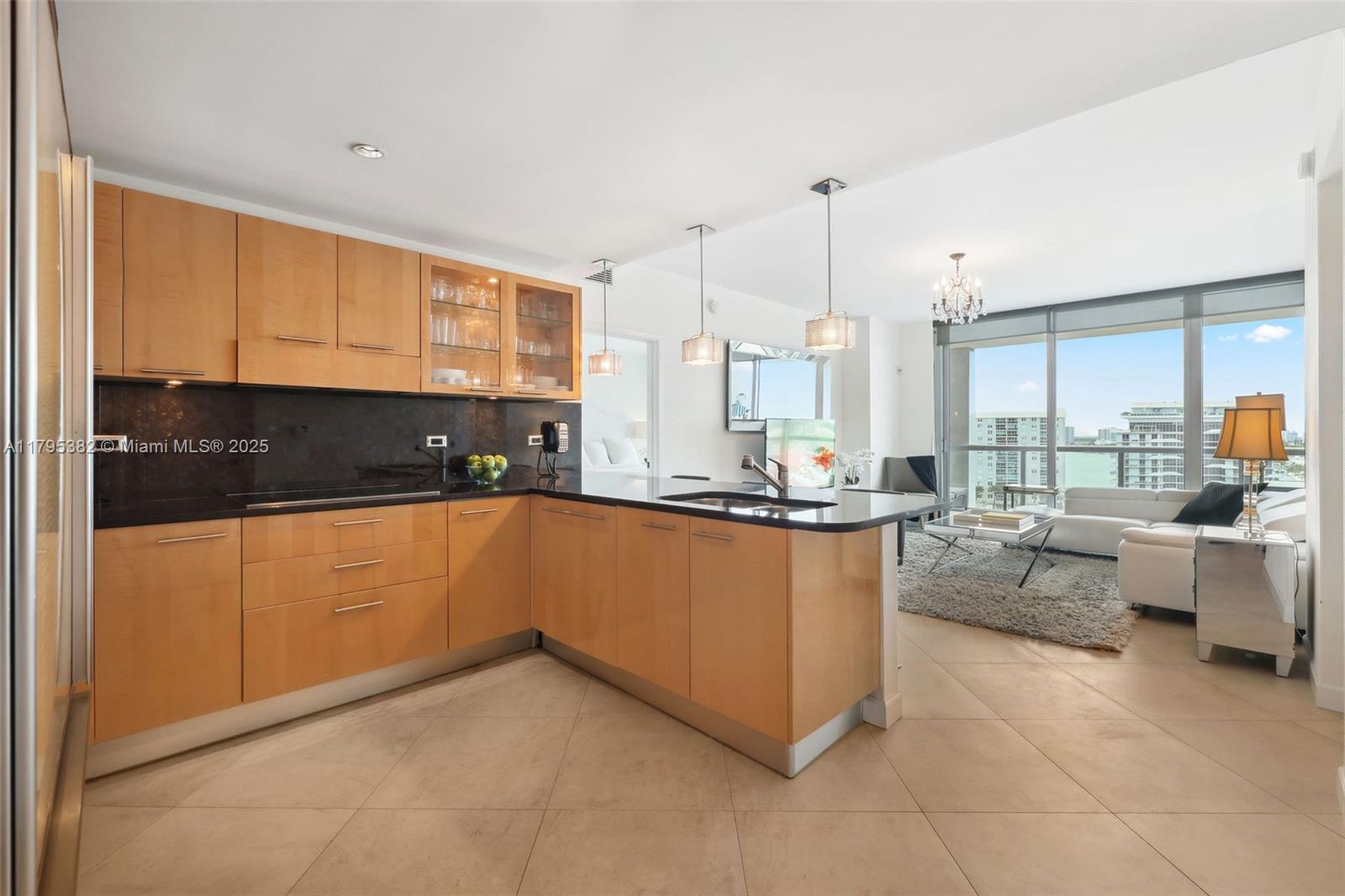 6799 Collins Avenue, Unit 1106 Miami Beach, FL 33141 - Photo 4 of 43 a kitchen with stainless steel appliances granite countertop a refrigerator a sink dishwasher a oven and white cabinets with wooden floor