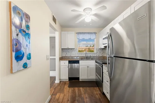 a kitchen with stainless steel appliances a refrigerator a sink a stove a microwave and cabinets