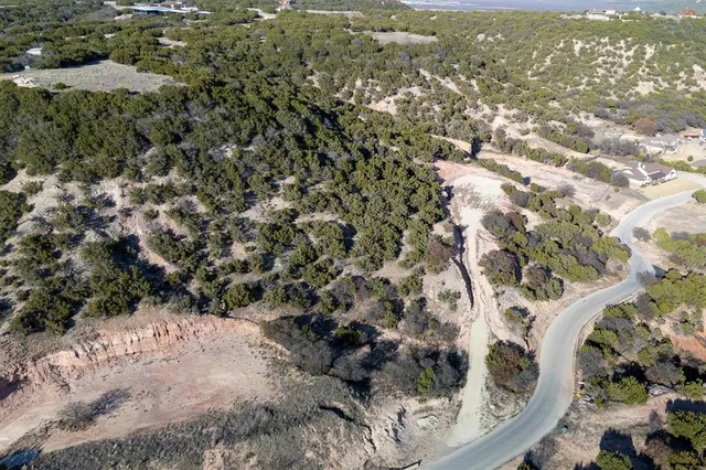 an aerial view of house with yard and mountain view in back