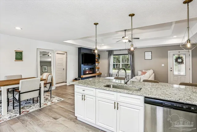 a kitchen with kitchen island granite countertop a counter space dining table and stainless steel appliances