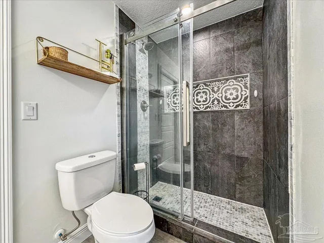 a white toilet sitting next to a bathroom