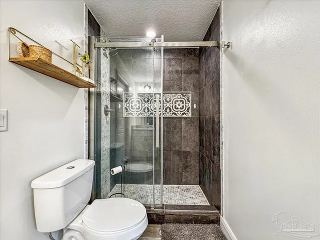 a bathroom with a toilet and a shower