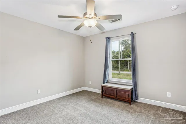an empty room with a ceiling fan and window