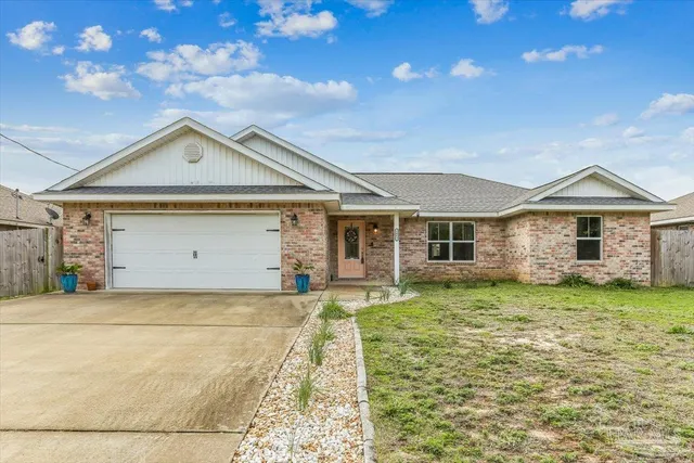 a front view of a house with a garden and yard