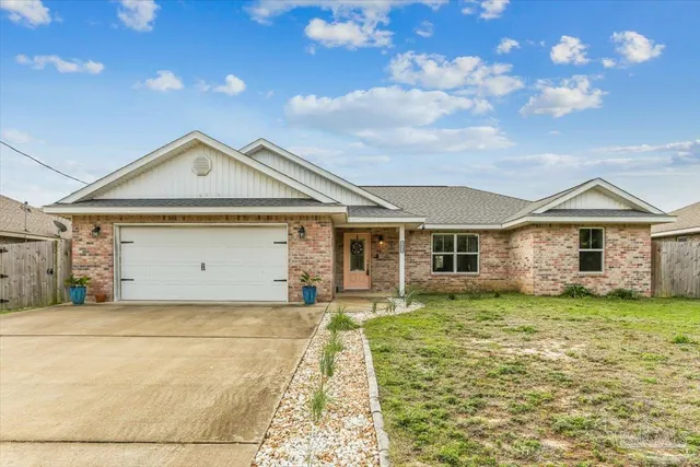 a front view of a house with a garden and yard