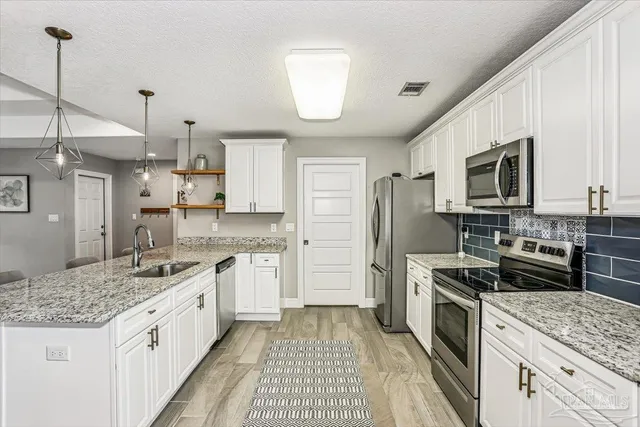 a kitchen with a sink stove and refrigerator