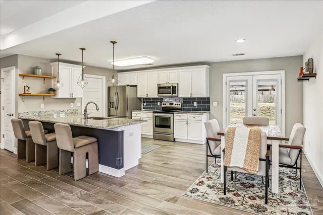 a large kitchen with cabinets table and chairs