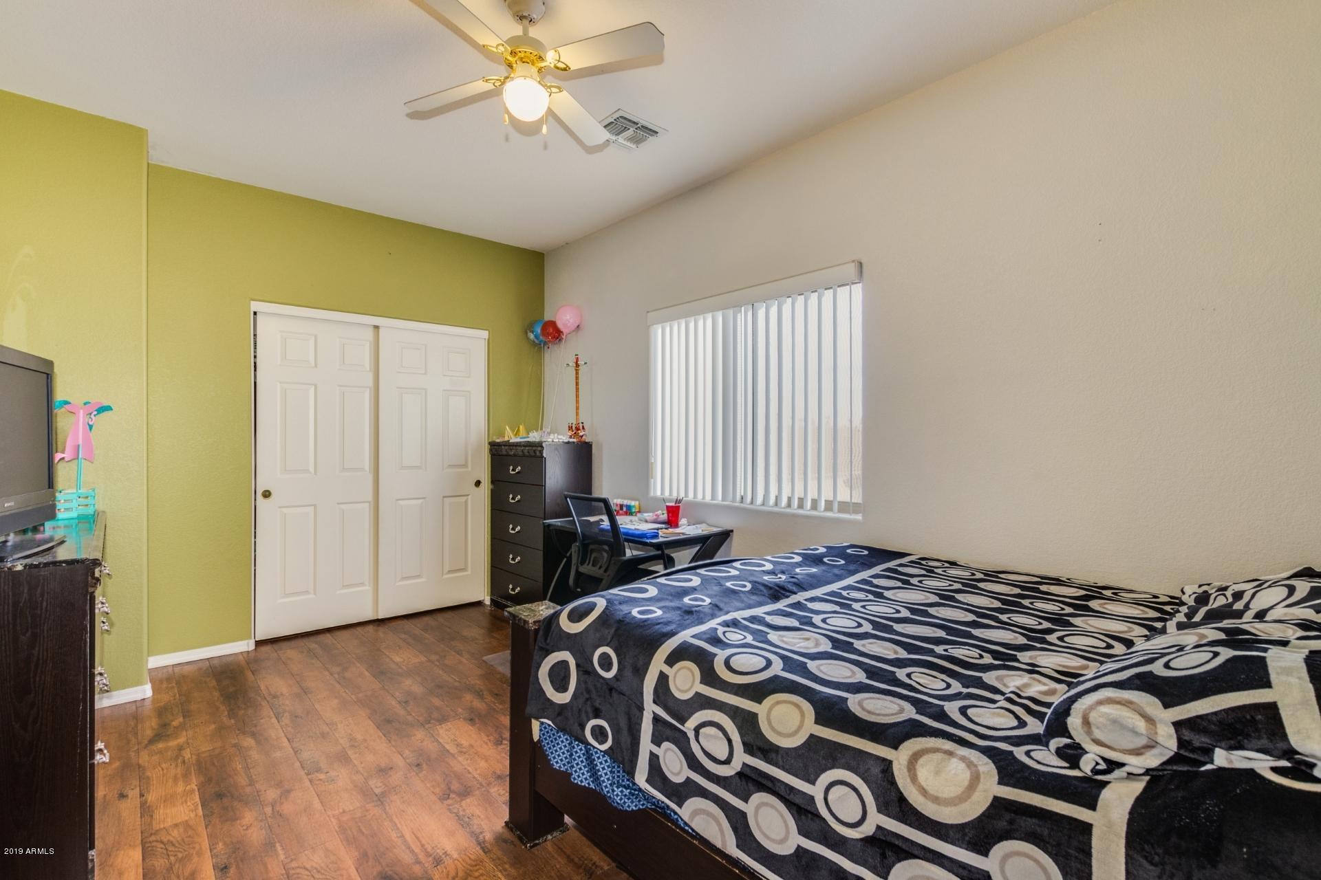 10434 East Bonnell Street Apache Junction, AZ 85120 - Photo 15 of 21 a bedroom with a bed and a chandelier