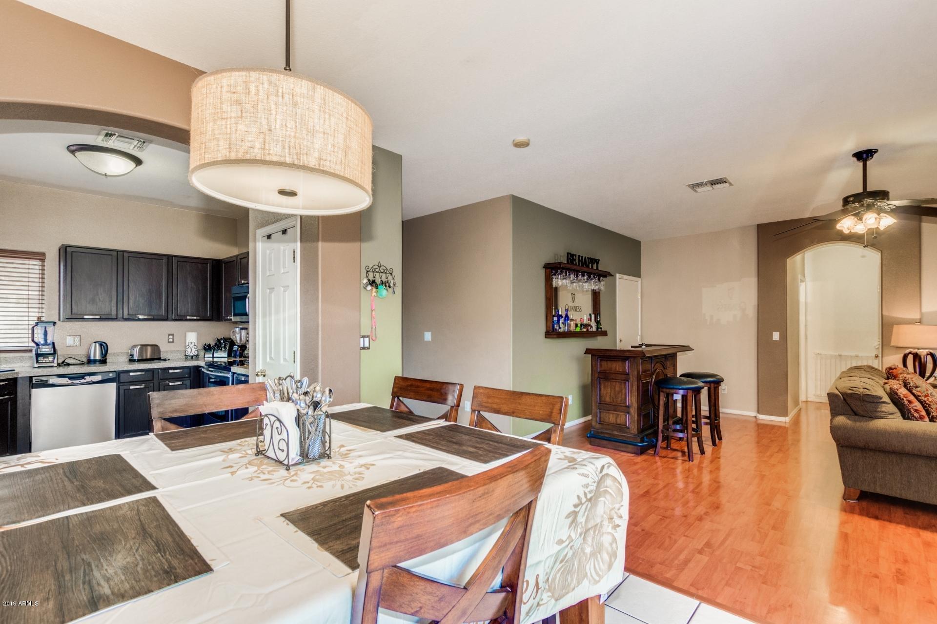 10434 East Bonnell Street Apache Junction, AZ 85120 - Photo 7 of 21 a view of a dining room with furniture a chandelier and wooden floor