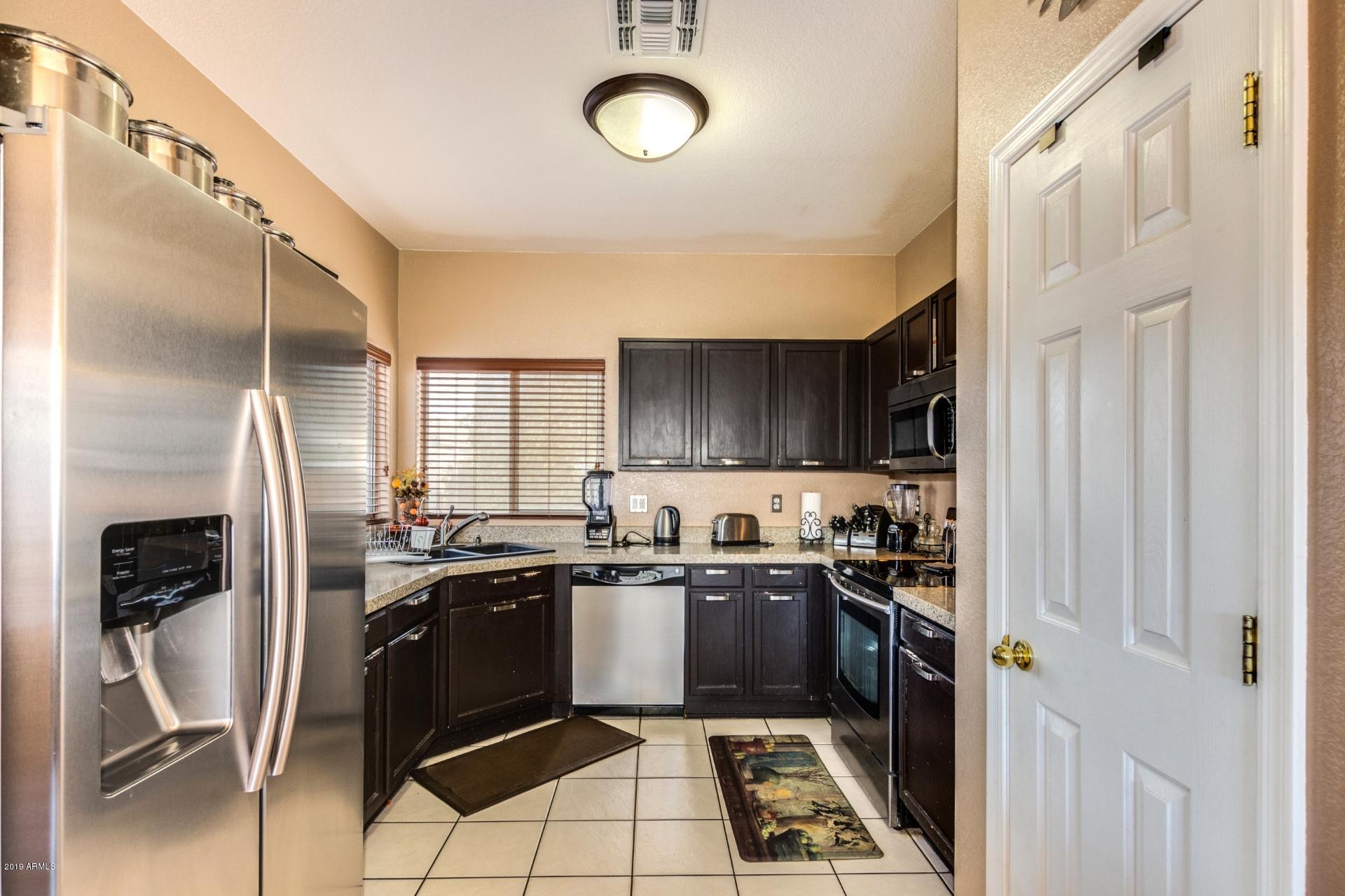 10434 East Bonnell Street Apache Junction, AZ 85120 - Photo 8 of 21 a kitchen with stainless steel appliances granite countertop a stove a sink and a refrigerator