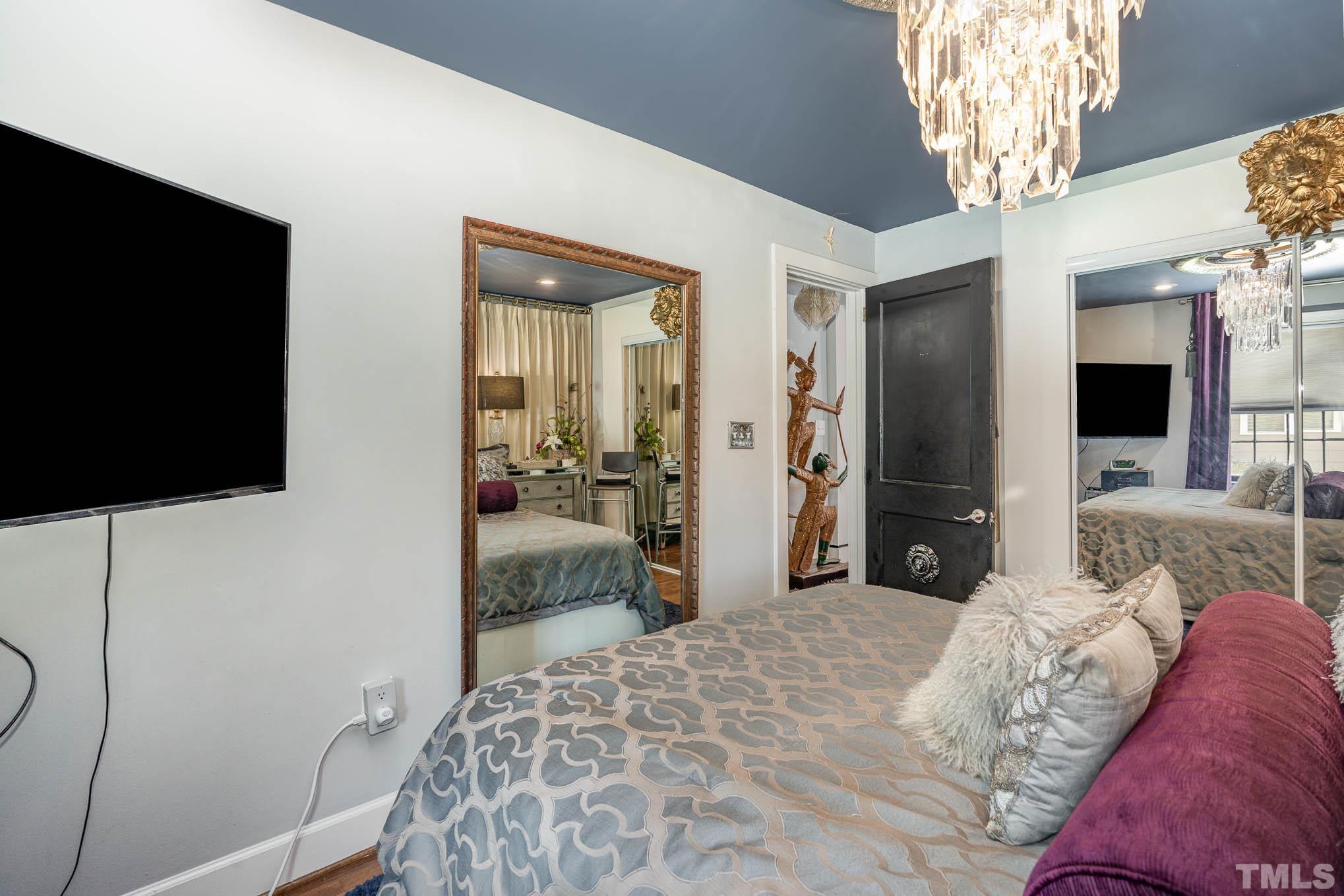2738 Newbold Street Raleigh, NC 27603 - Photo 14 of 18 a bedroom with a bed and a chandelier