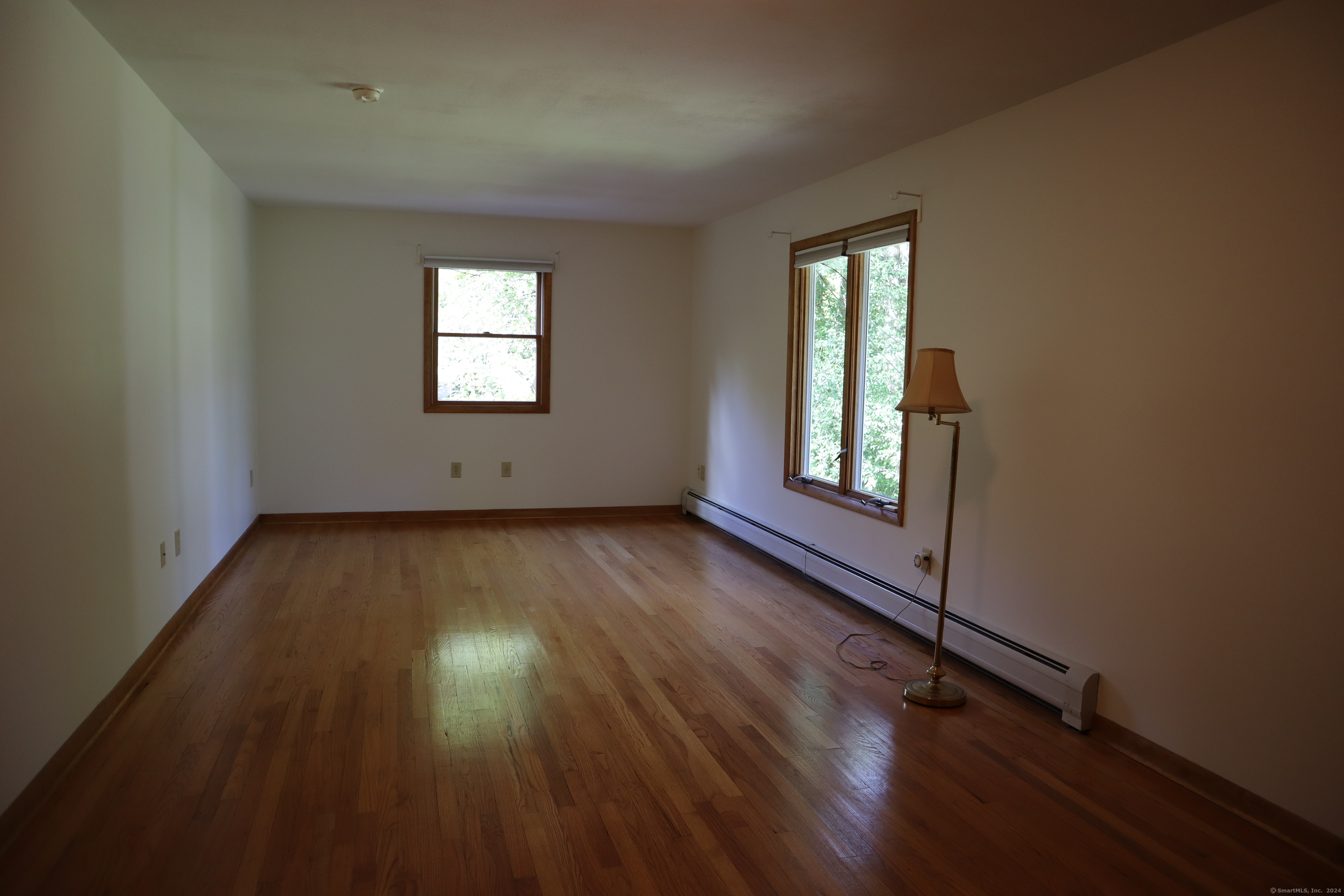 151 Chestnut Ridge Road Bethel, CT 06801 - Photo 13 of 23 an empty room with wooden floor and windows