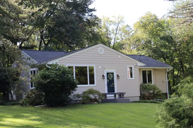 a front view of house with a garden and trees