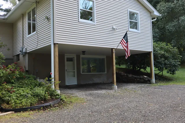 a view of a house with a yard and sitting area