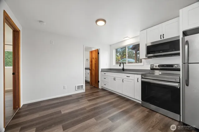 a kitchen with granite countertop a refrigerator and a sink