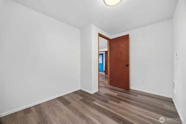 a view of a room that has wooden floor and fan